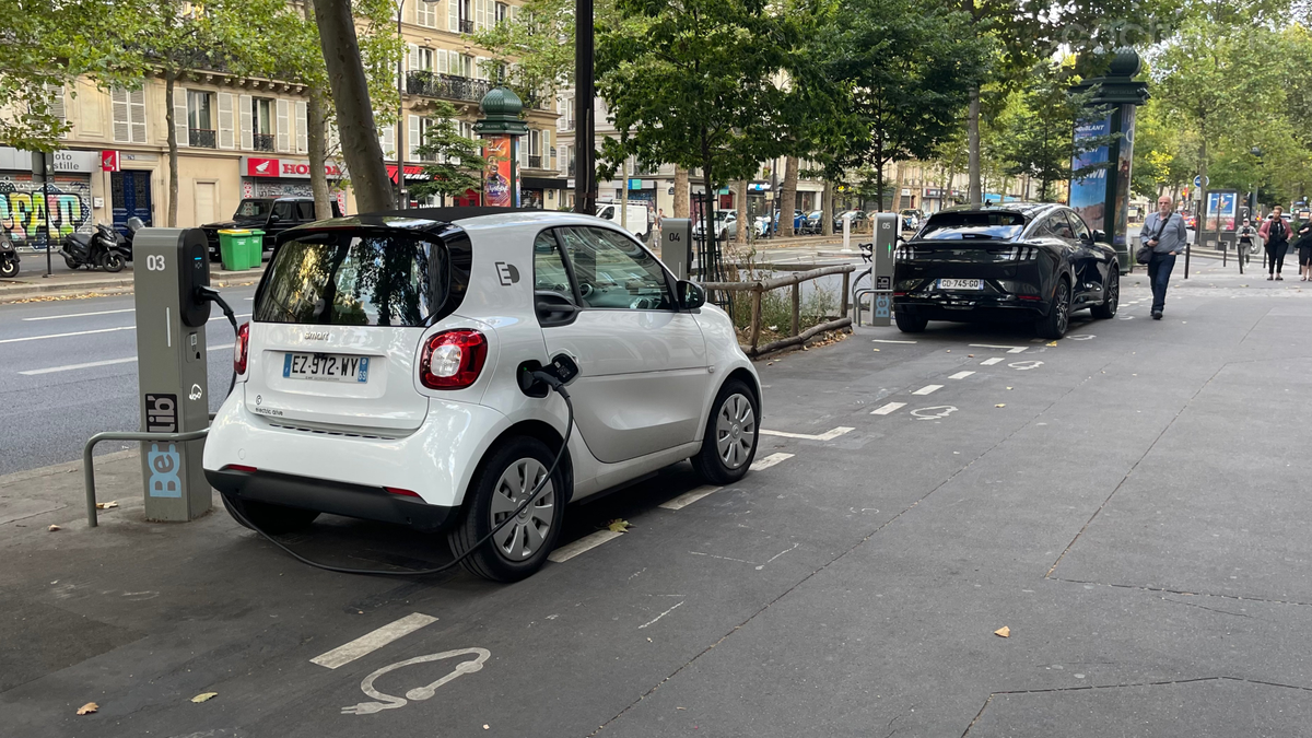 Dos eléctricos cargando en París. El Mustang Mach-e del fondo pagará el triple que el Smart para aparcar en la capital francesa.